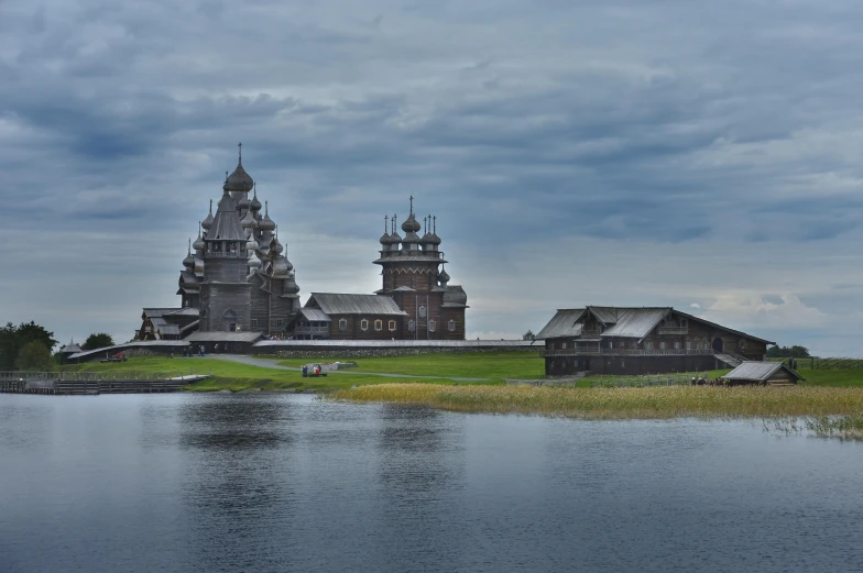 an old church on a cloudy day by water