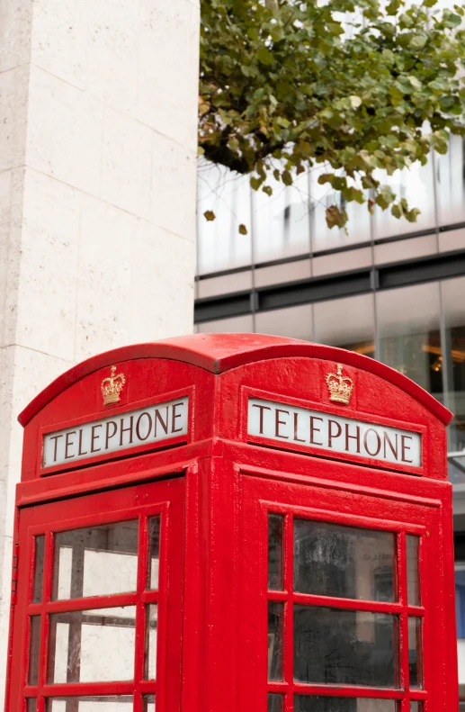the two telephone booths are red with gold emblems