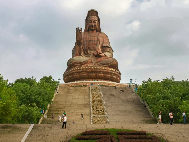 people are standing next to a large statue