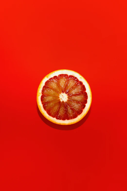 an orange sitting on top of a red surface