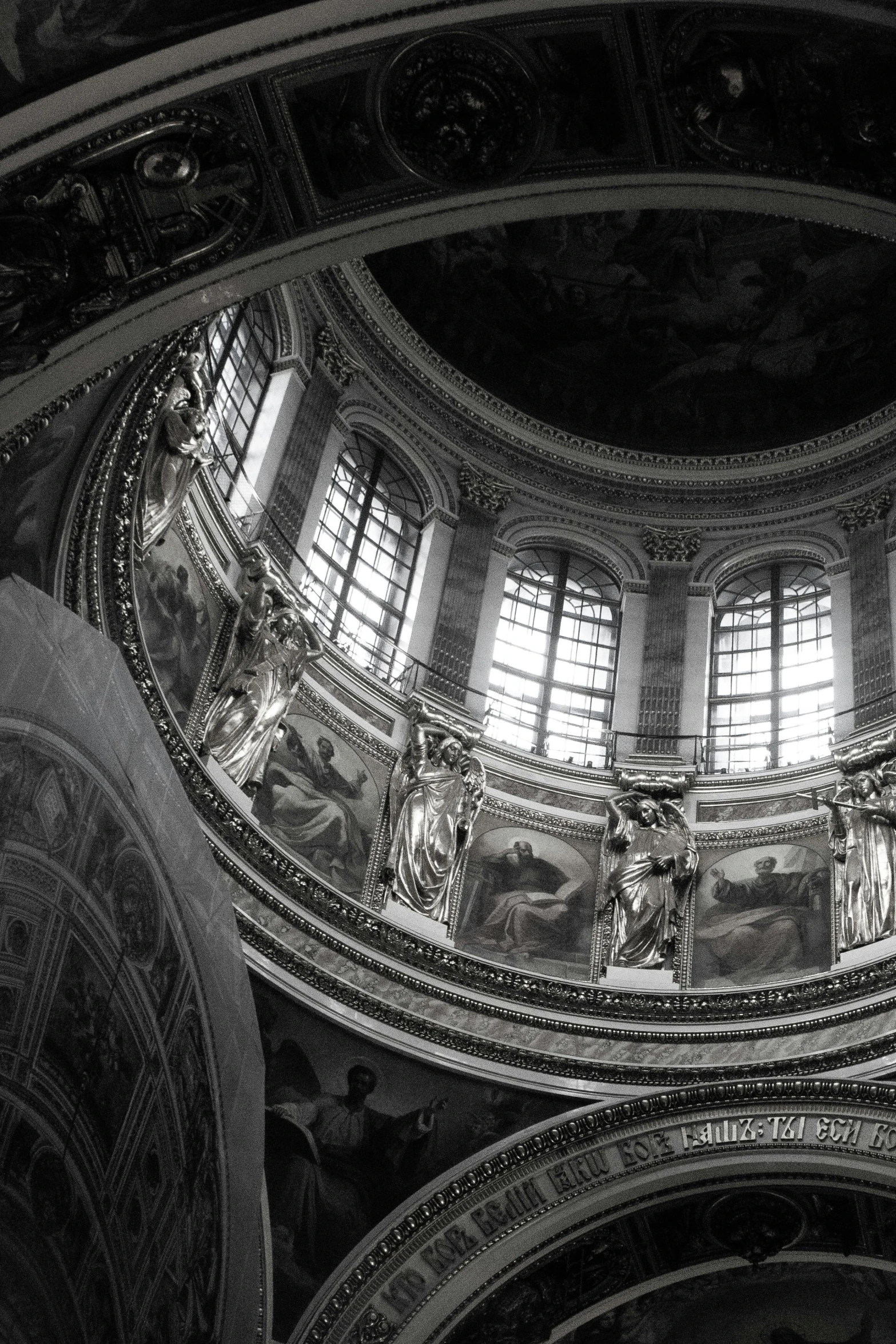 a ceiling with windows and many statues around it