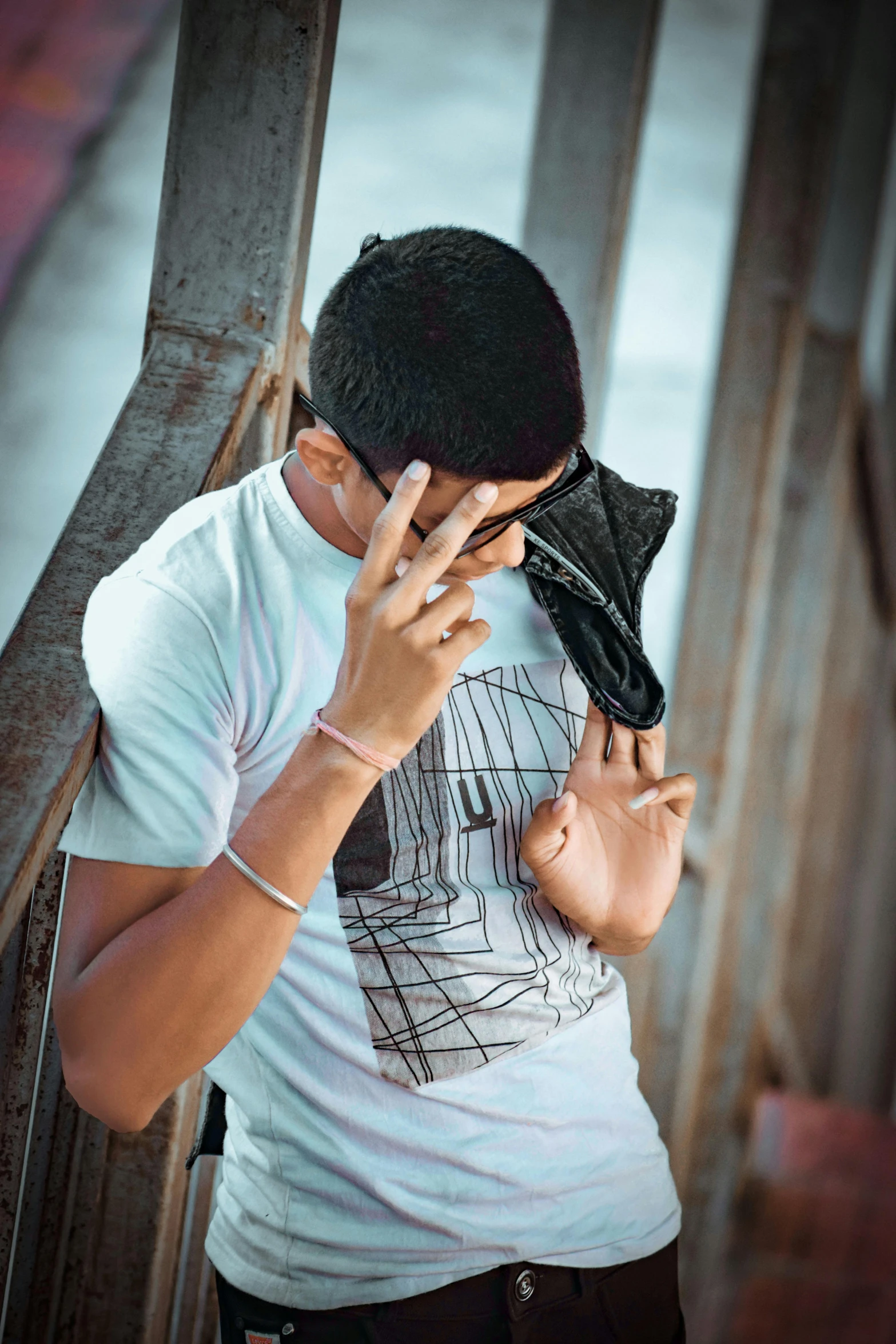 a man standing in front of a wooden fence talking on a phone