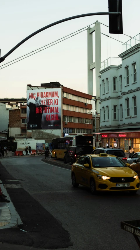 a city intersection with several traffic lights and billboards in background