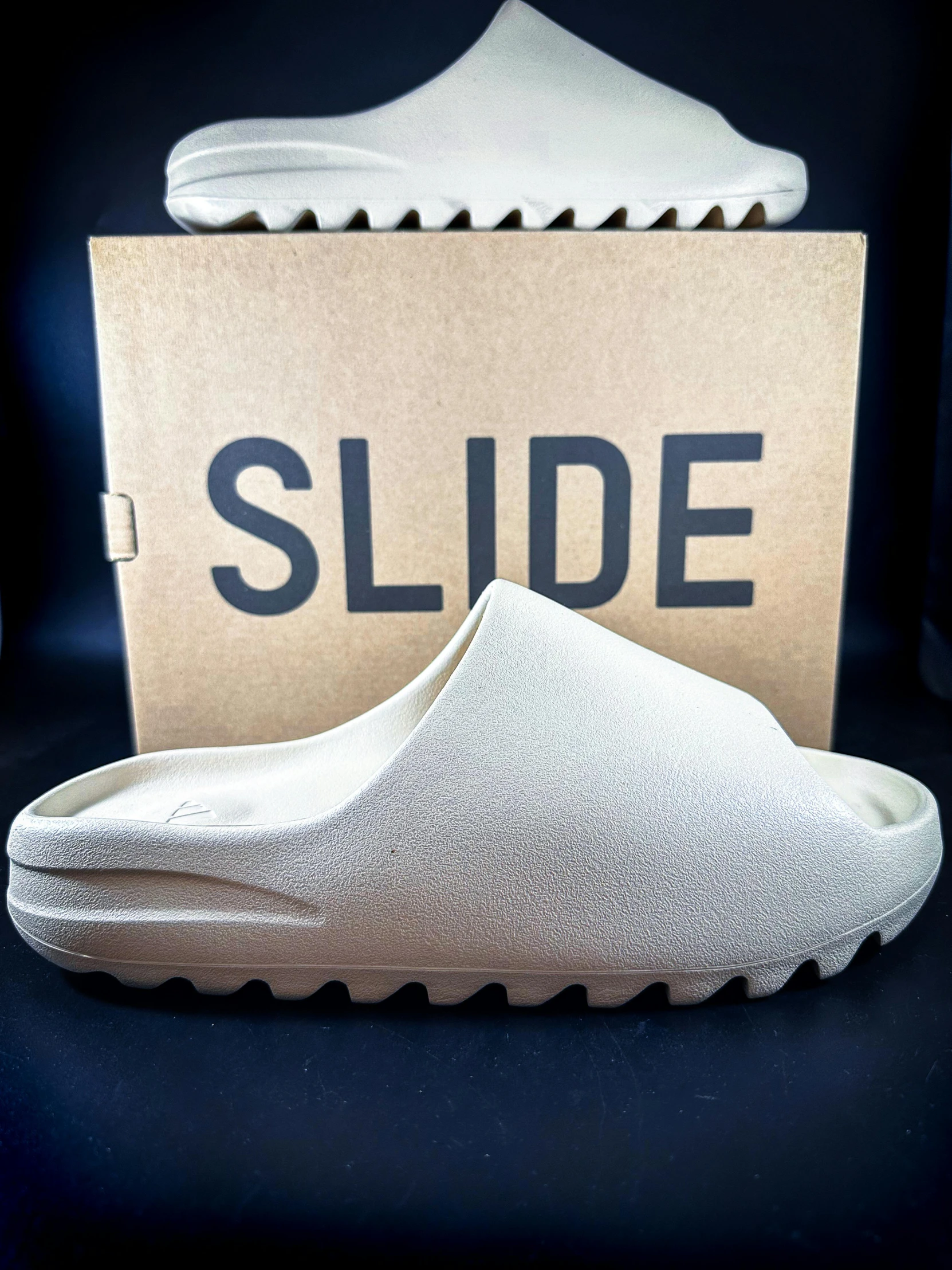 a pair of white shoes sitting next to a box