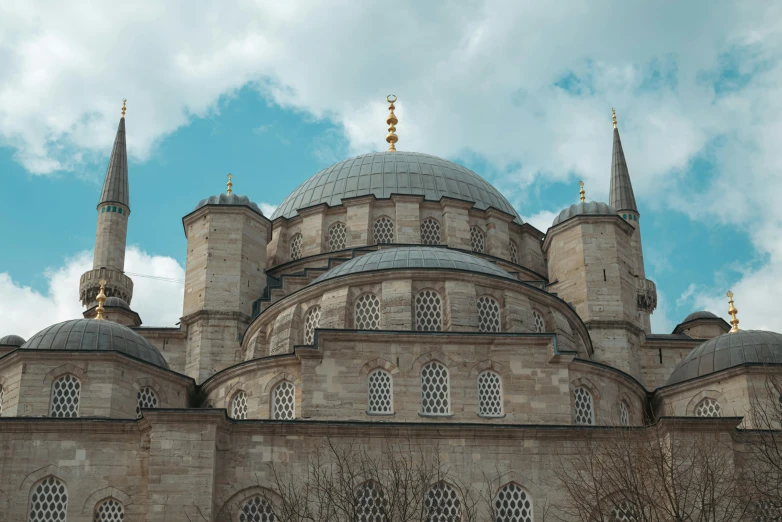 an ornate building with three domes against the sky