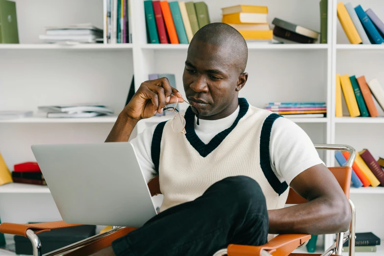 a man in white shirt and black pants using a laptop computer