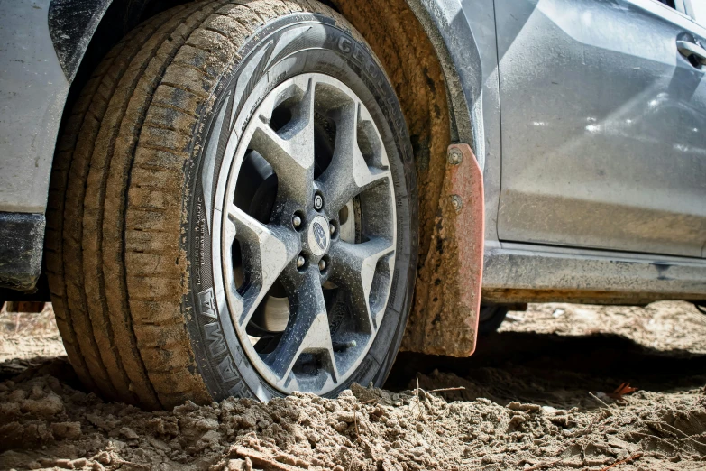 mud covered tire of a compact suv on muddy ground