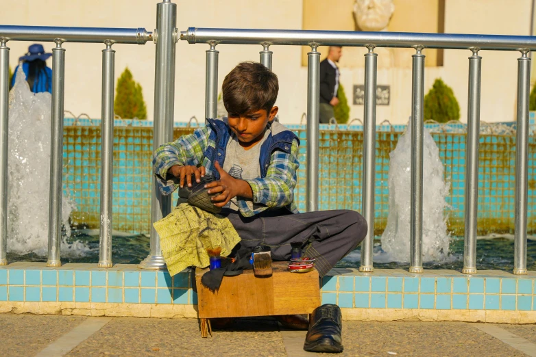 a boy plays with his toys in front of the fountain