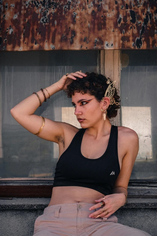 a woman sitting on the side of a building wearing shorts