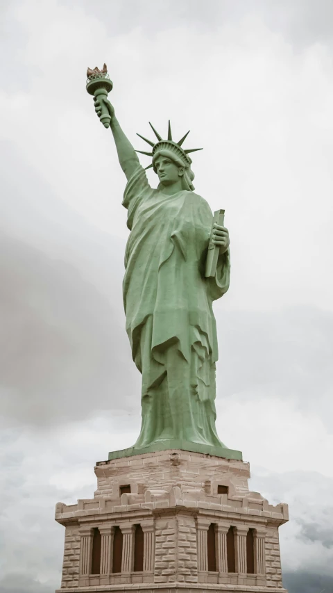 the statue of liberty stands in the middle of a large park