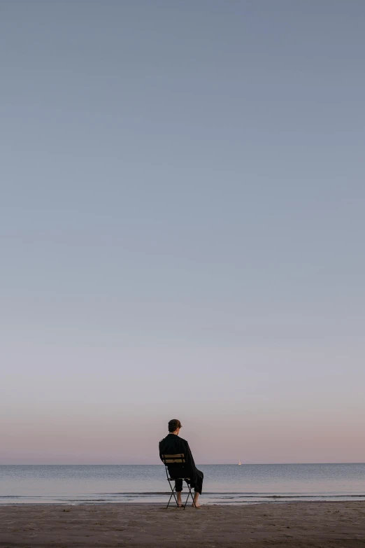 a person is on the beach looking at the ocean