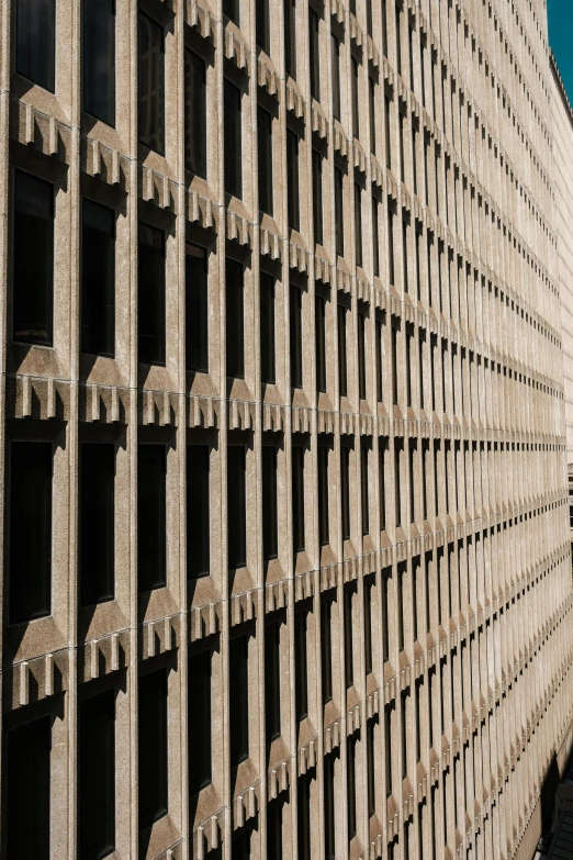 a tall stone building with windows and bars on it