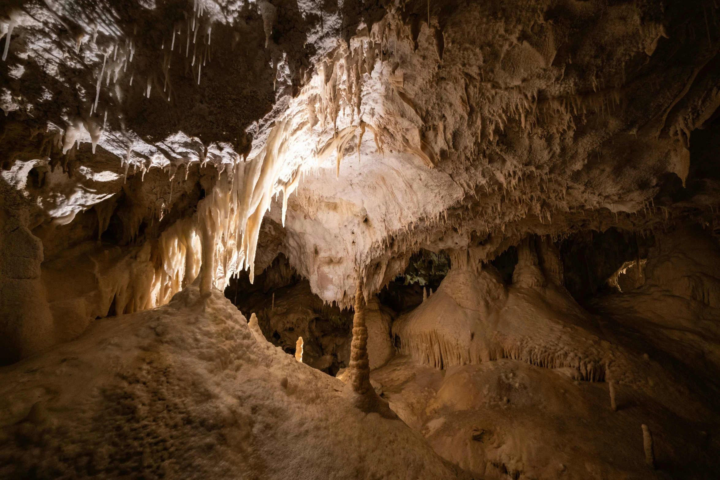 the inside of a cave with some light shining on the wall