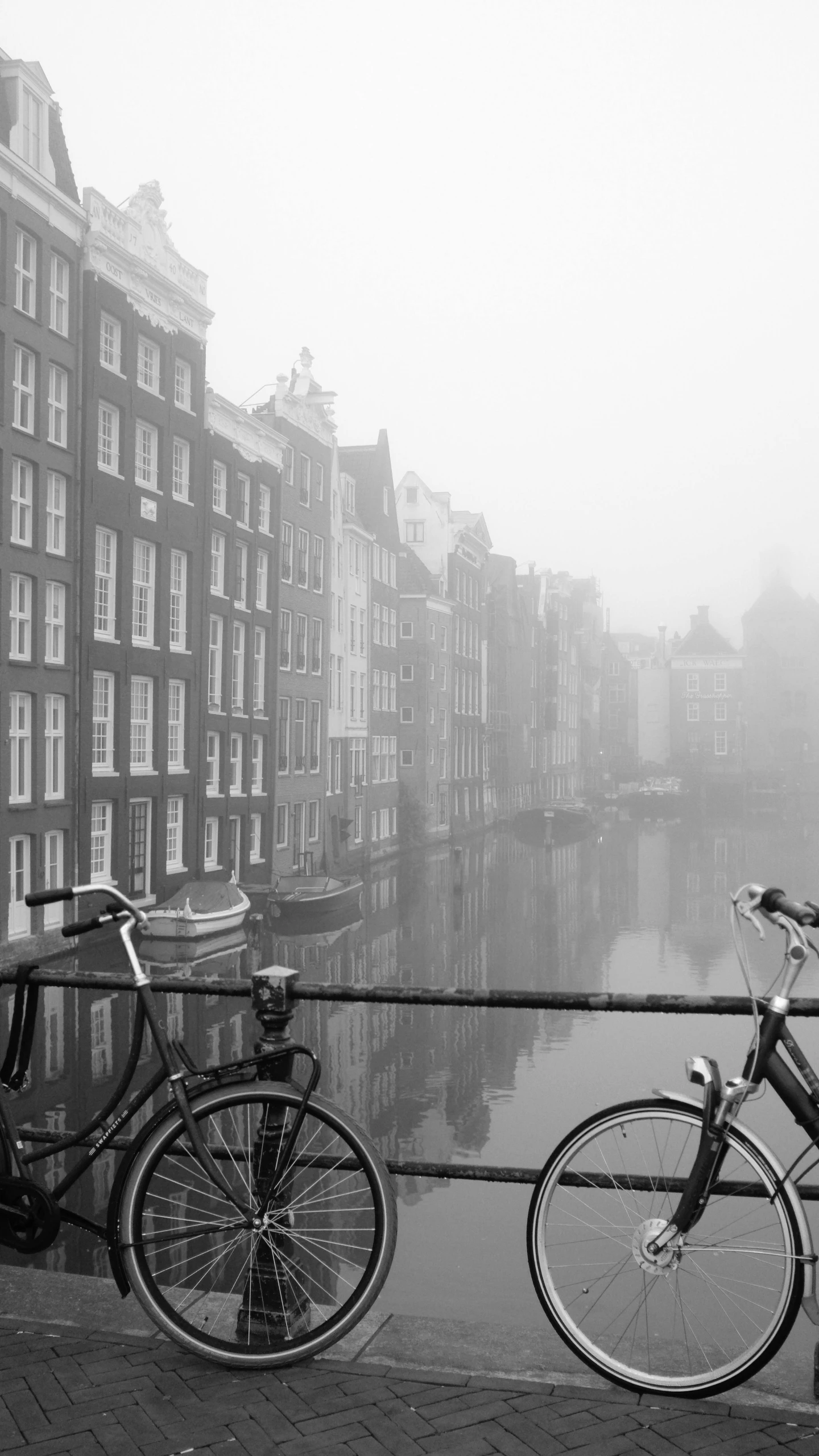 two bikes are next to the railing near the water