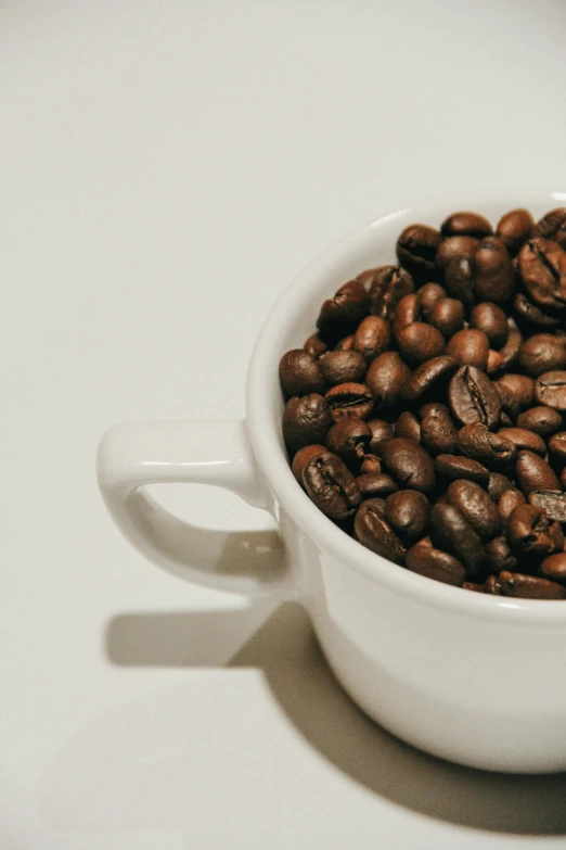 coffee beans are in a cup on a table