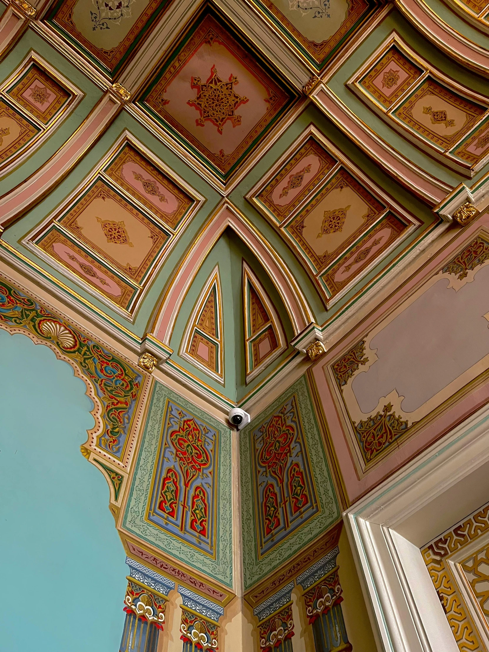 a building with a ceiling with clocks and painted plaster on it