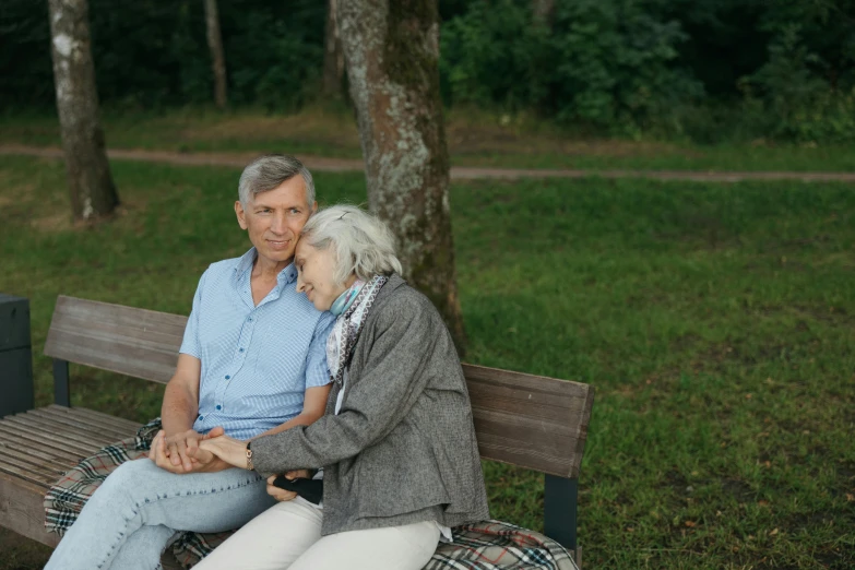 an older couple are sitting on a bench