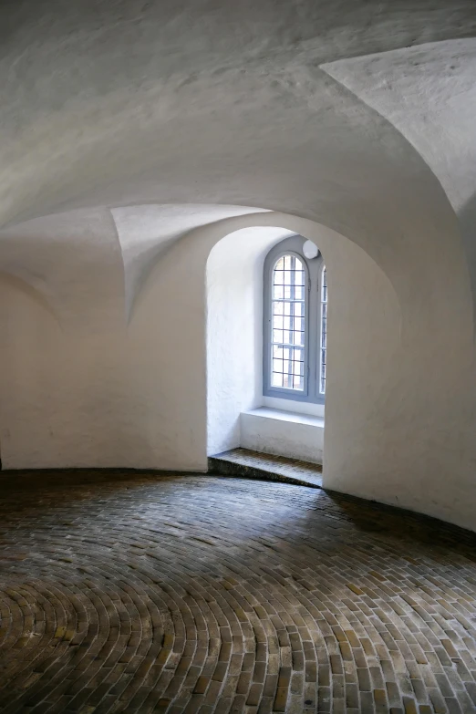 a room with arched windows and cobblestone floor