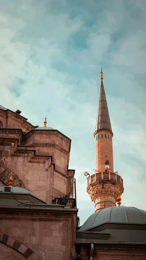 two large buildings with gold spires in front of a cloudy sky