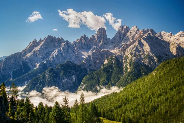 some clouds flying in front of some mountains