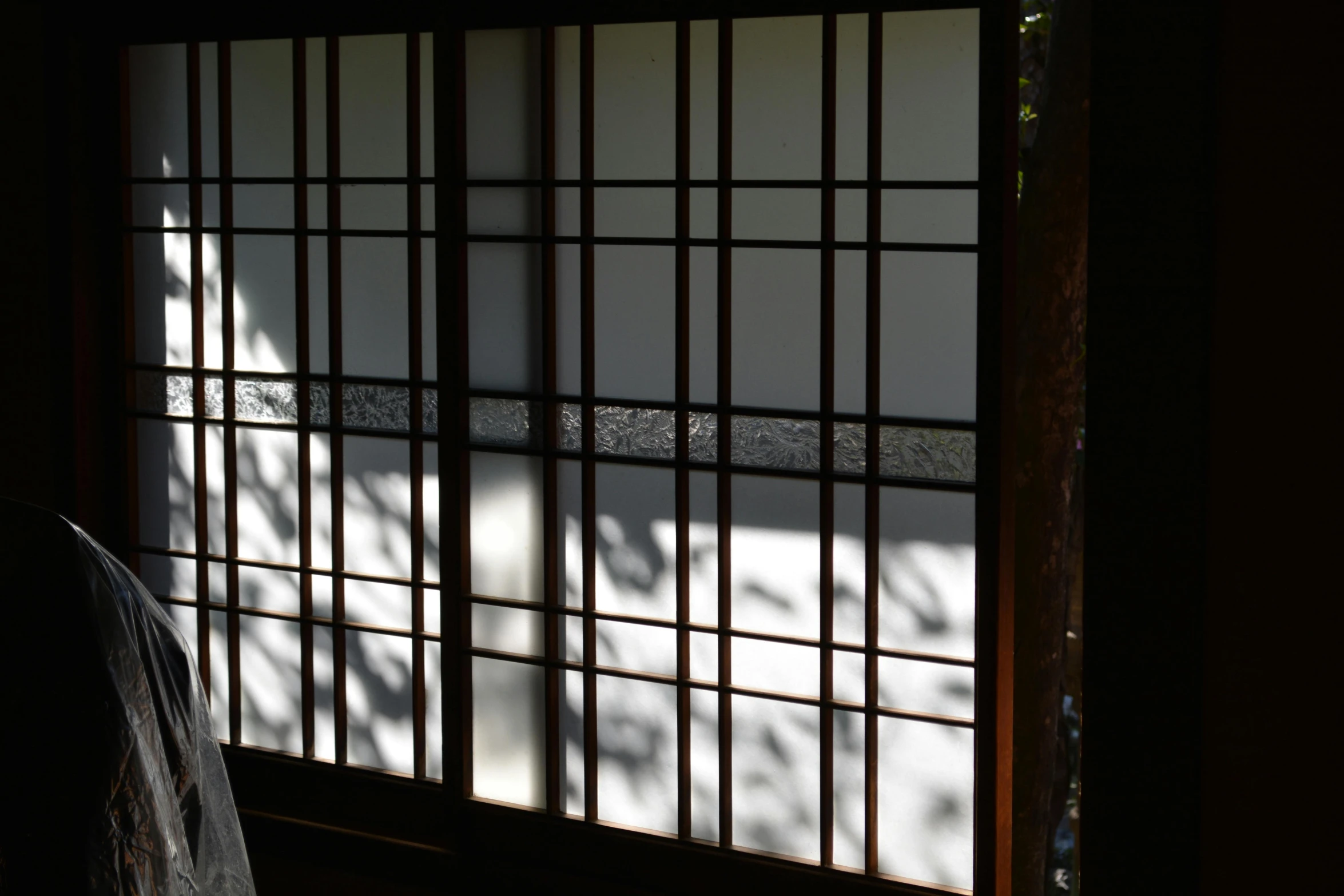 a window with bars on it and a chair next to it