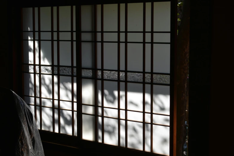 a window with bars on it and a chair next to it