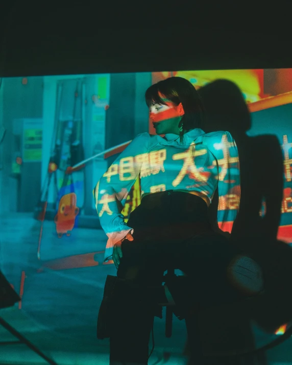 a woman standing behind a motorcycle next to a colorful wall