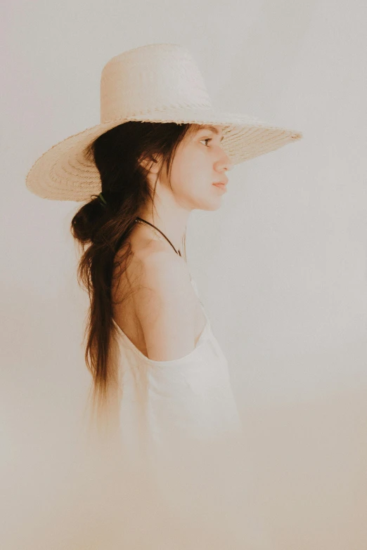 a woman wearing a large hat with long hair