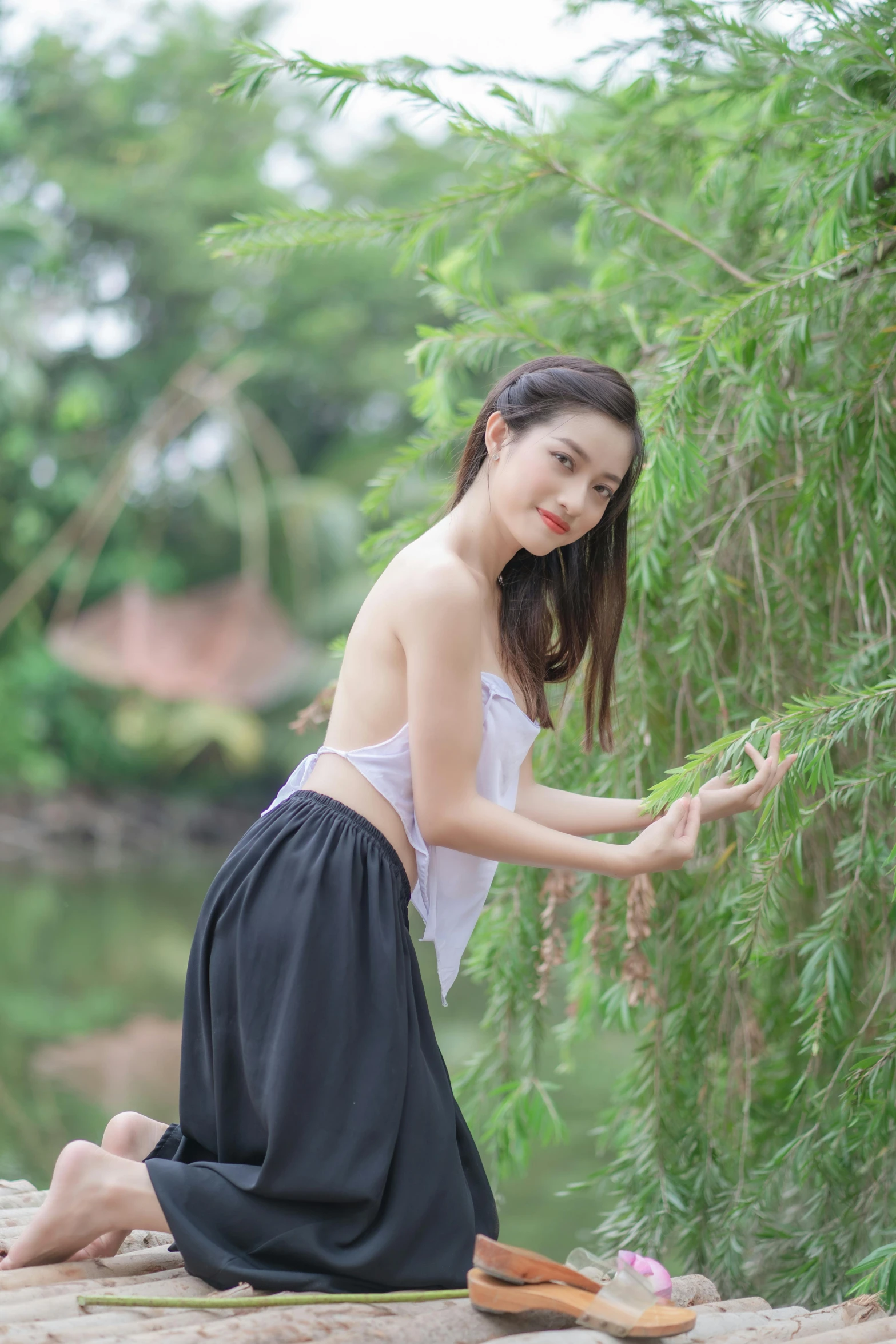 a girl squatting down and holding some bamboo