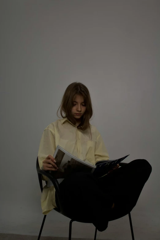 a woman is reading in an open chair