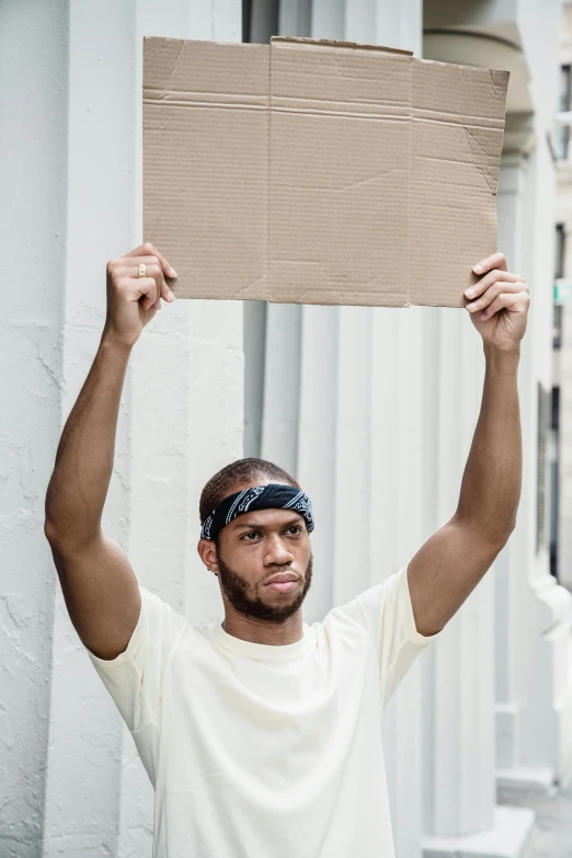 the man is holding up a piece of cardboard