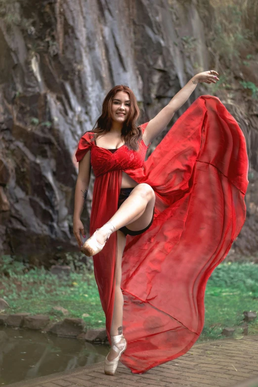 a young woman in red dresses standing on a path