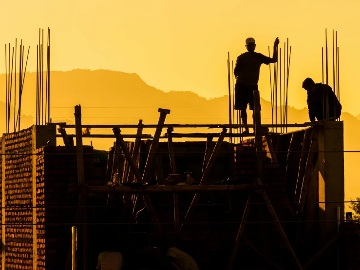 a man on the top of a construction site at sunset