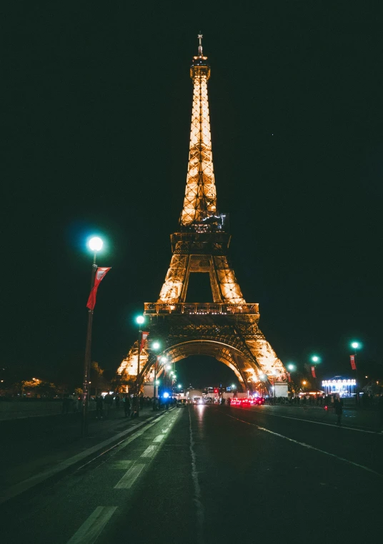 the eiffel tower at night is glowing yellow