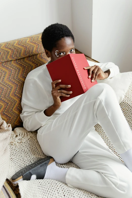 a person is on a bed with a book