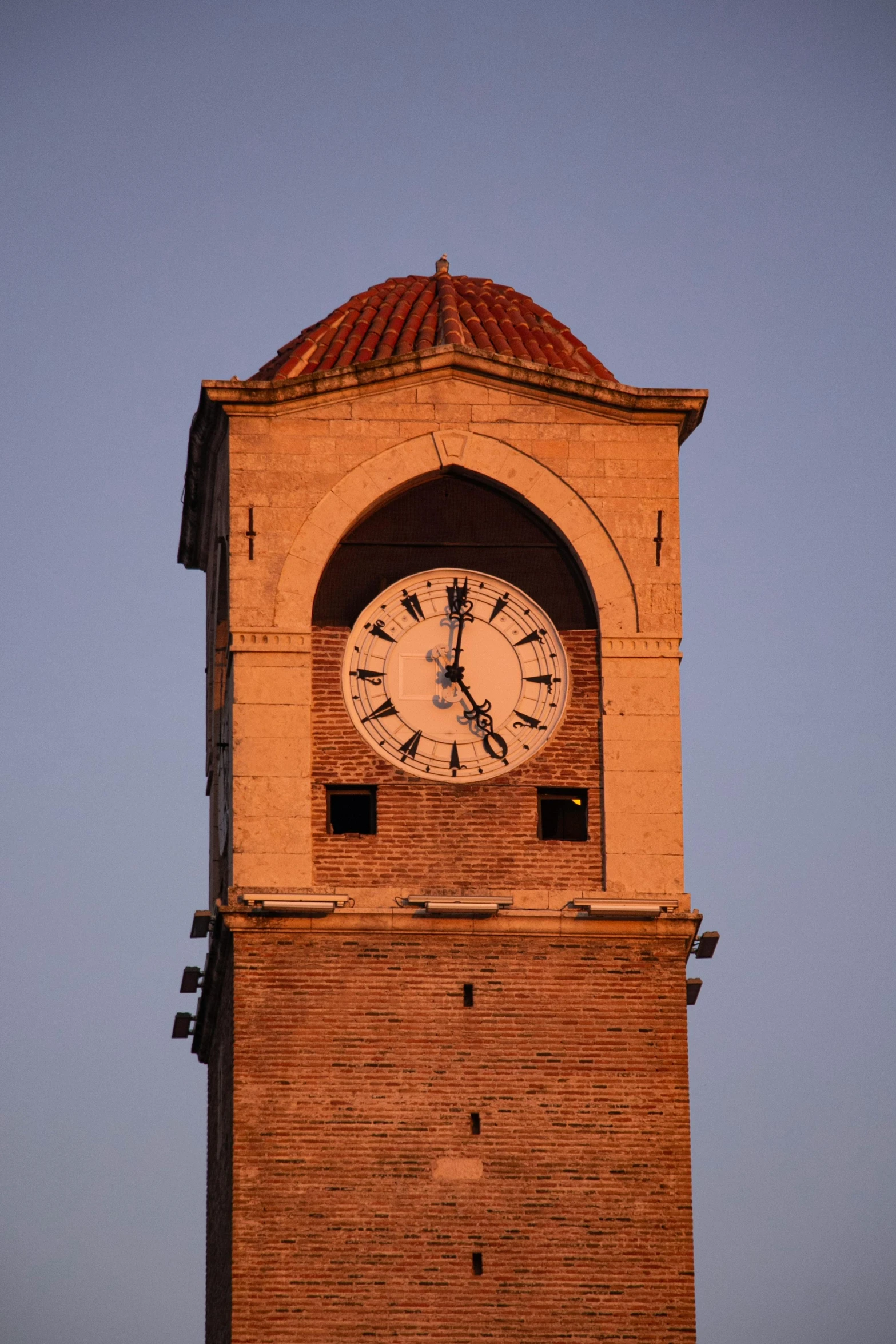 an old brick building with a clock at the top of it