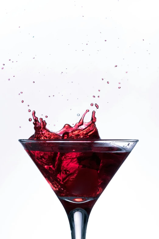 red liquid splashing into a martini glass