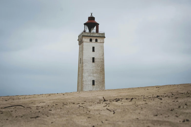 a lighthouse is on the top of a hill