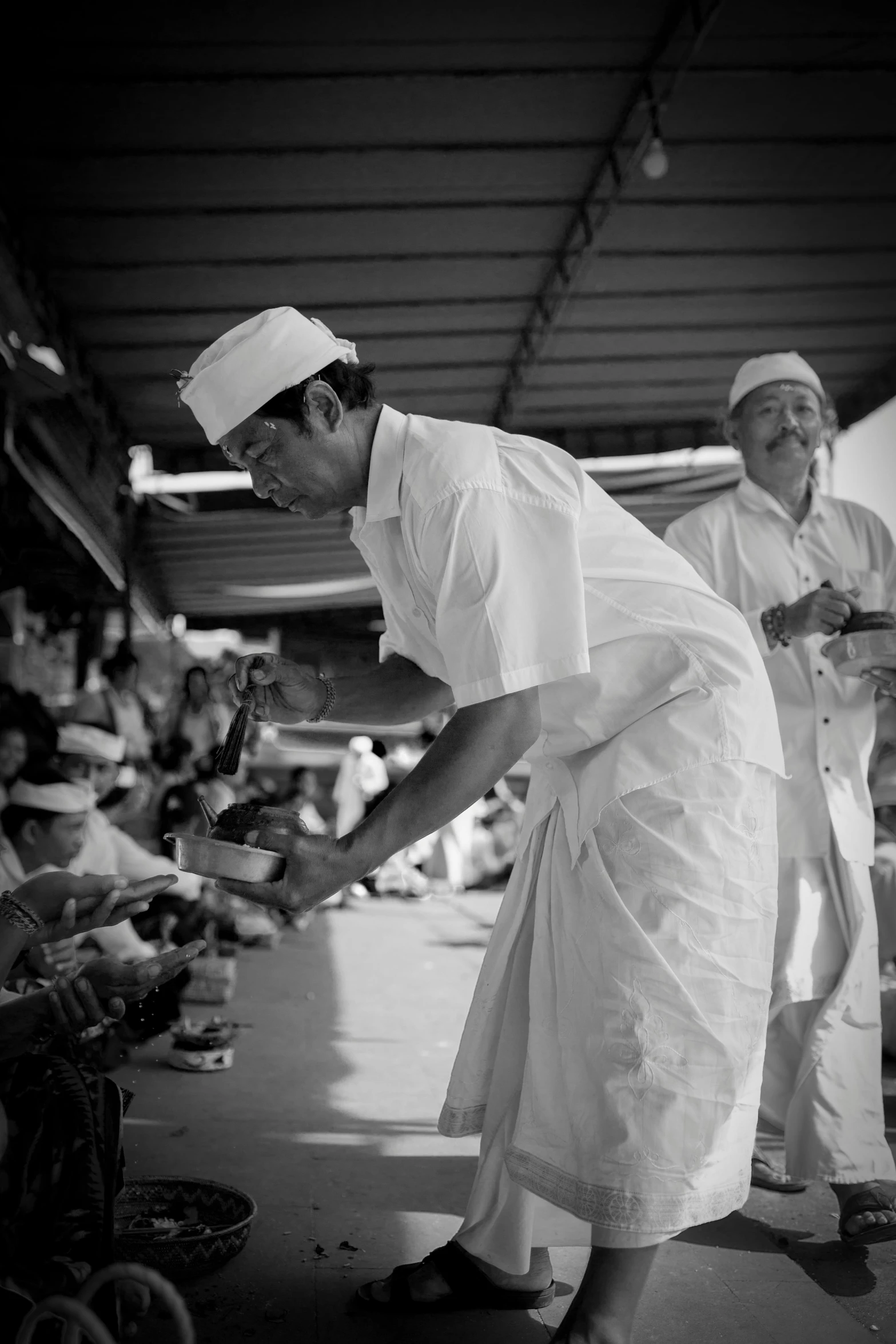 two men in chef uniforms preparing food on plates