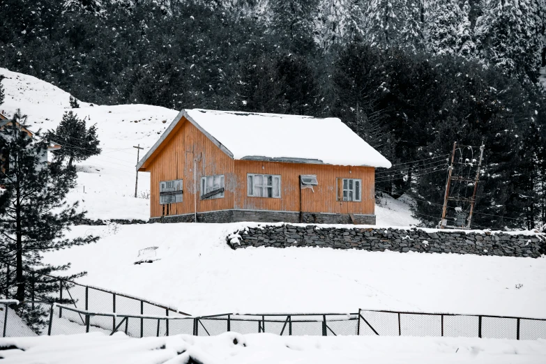 a house is covered in snow by a fence