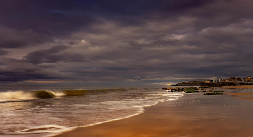 storm clouds hovering over the beach and houses