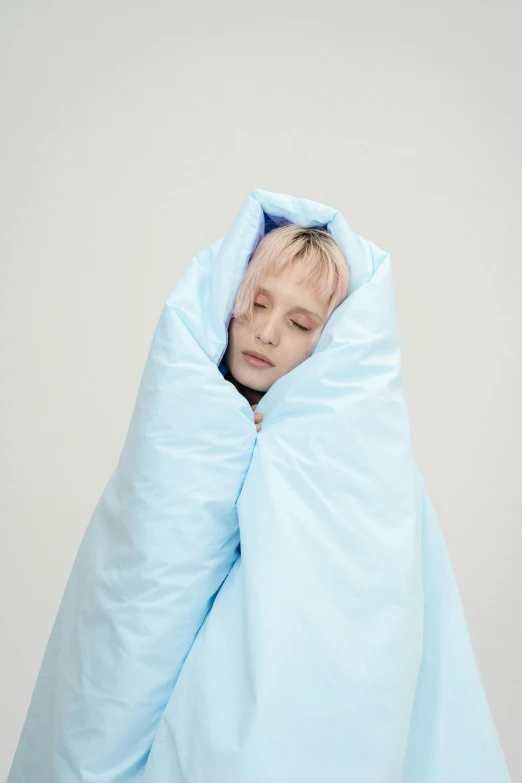 a boy is sleeping in a small blanket