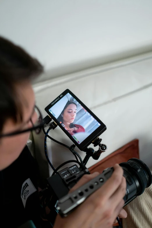 woman looking at a video camera with her picture of an asian woman on the screen