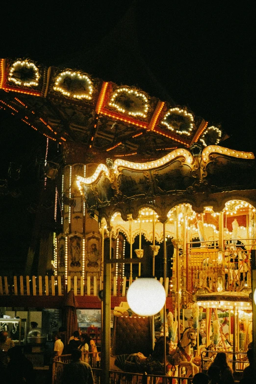 several people ride a merry go round on a dark day