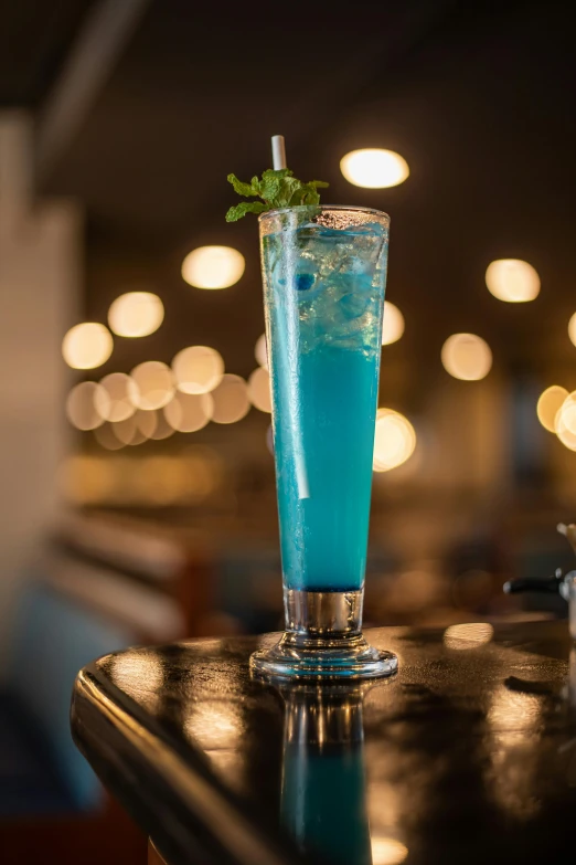 a cocktail on a bar with some blurred lights