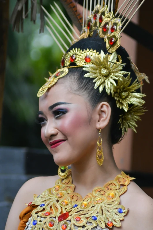 young woman with elaborate headdress smiling at soing