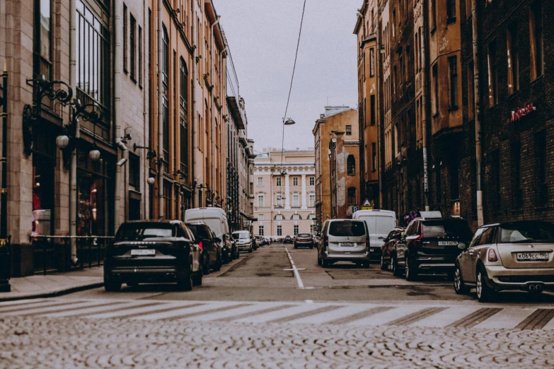 an empty city street has many vehicles parked along it