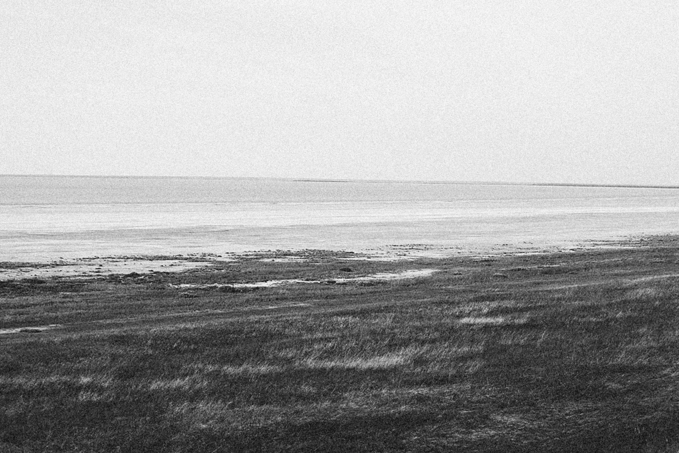 a couple walking on the beach together by the water