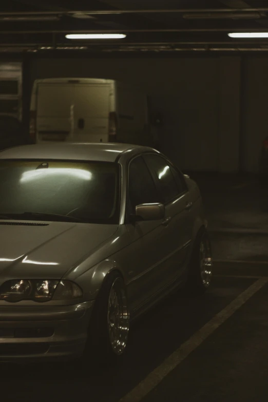 a silver car parked next to a white van