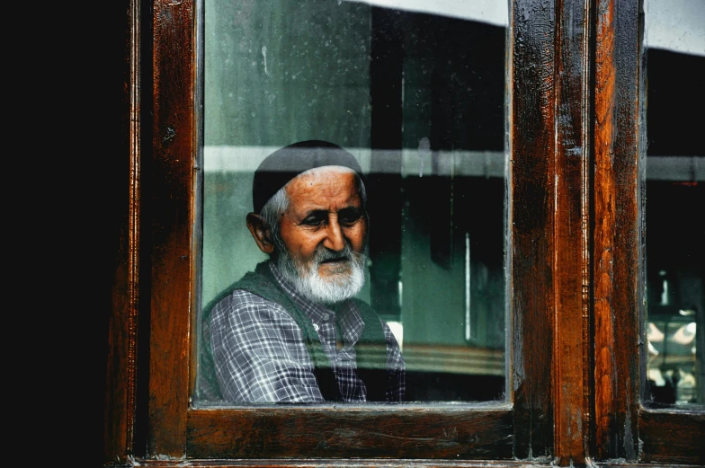 a man staring out of a window on a rainy day